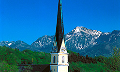 Ortsbild Prien mit Kirchturm und bl&uuml;hendem Obstbaum