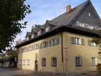 Die Musikschule in Prien ein großes gelbes Gebäude mit grauen Fensterläden